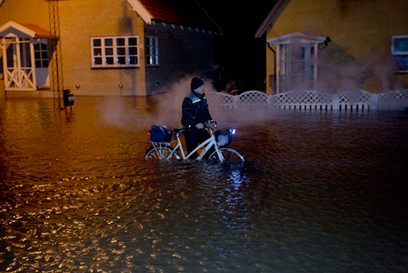 Mand kæmper sig igennem vandmasserne ved stormfloden i december 2013. Foto: Kenneth Jensen.